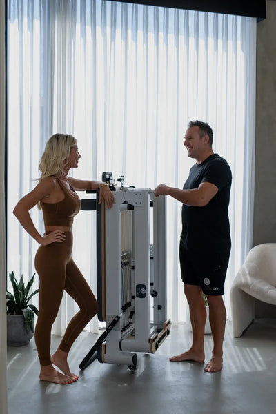 Compact Pilates reformer with folding frame, designed for home or studio use, featuring space-saving storage and smooth-glide carriage.
