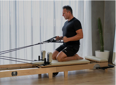 Folded Pilates reformer designed for small spaces, featuring a lightweight, collapsible frame for easy storage.